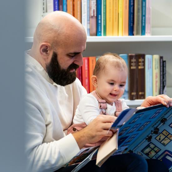 Mand sidder med lille barn